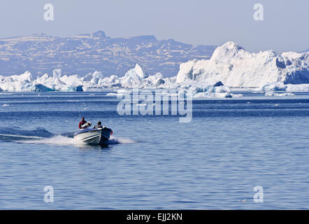 ILLULISAT, QAASUITSUP / GREENLAND - JUNE 17: A small fisihing boat returns to harbour from the Jakobshavn icefjord Stock Photo