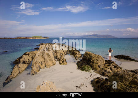 iona beach and young woman gazing out to the blue sea Stock Photo