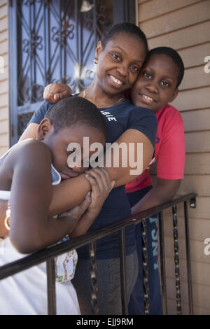 Portrait of mother and two sons on their back porch in Brooklyn, NY. Stock Photo