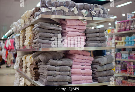 Piles of soft colored towels on the shelves in a shop Stock Photo