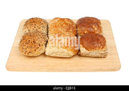 Mixed bread rolls on a wooden board isolated against white Stock Photo