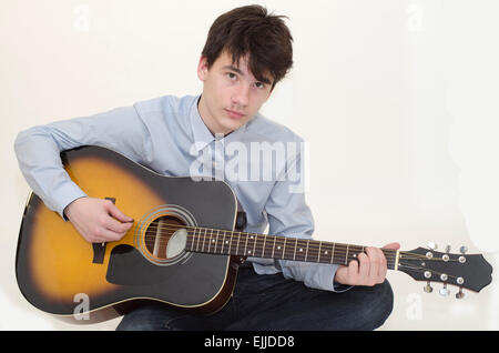 Teenager playing guitar isolated on white Stock Photo