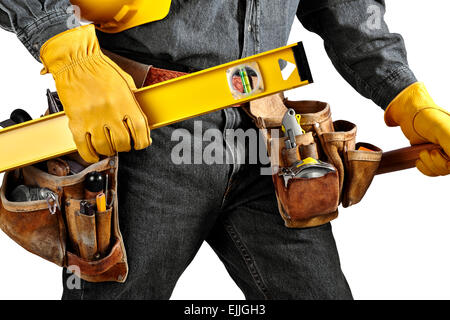 Man in black denim wearing used tool belt filled with carpenter tools carrying a yellow level, hardhat and hammer Stock Photo