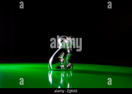 Silver little dog figurine isolated over green background Stock Photo