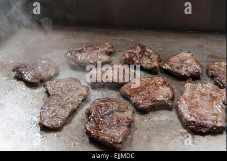 Closeup of beef steaks cooking at a hotel restaurant buffet Stock Photo