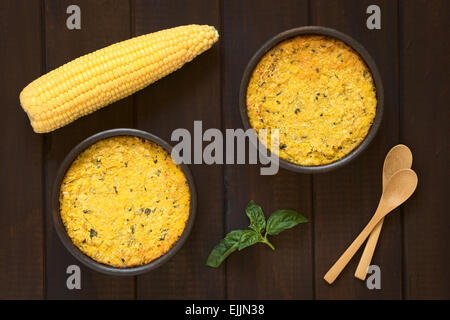 Overhead shot of traditional Chilean corn pie called Pastel de Choclo served in bowls, photographed on dark wood Stock Photo