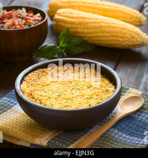 Bowl of traditional Chilean corn pie called Pastel de Choclo served with Pebre sauce in the back, photographed on cloth Stock Photo