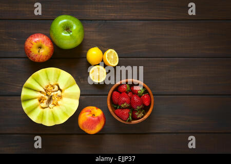 Overhead shot of a variety of fresh fruits (honeydew melon, nectarine, apple, strawberry, plum, lemon) Stock Photo