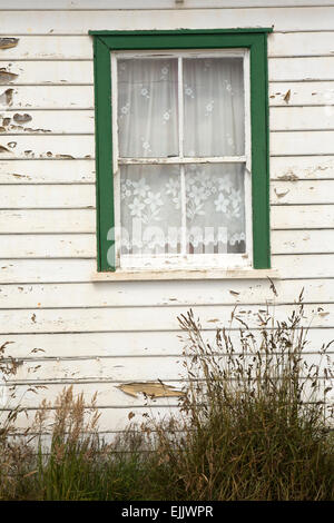 Falklands, Port Stanley, Allardyce Street, peeling painted window of wetherboarded cottage Stock Photo