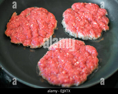 Ground beef patties in the pan. Stock Photo