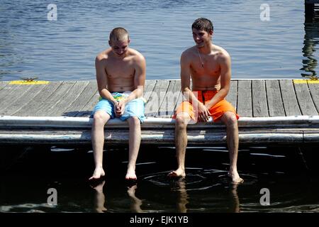 Boys in bathing suits sitting on a dock in Homosassa, Florida Stock Photo