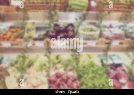 Blurred background of vegetable shelves in a shop. Designed to work with text overlays including the text colour white. Artistic Stock Photo