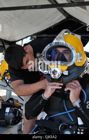 Army engineer diver, Specialist Daniel Nagel, foreground prepares for a surface supply dive as Spc. Rodrigo Novoa right checks the KM-37 Diving Helmet, the afternoon of June 2, at Aberdeen Proving Ground, Md. Both Soldiers are assigned to the 74th Engineer Dive Detachment, Special Troops Battalion, 7th Sustainment Brigade. The group of 85 Army engineer divers assigned to the 74th, 86th, 511th, 544th and 569th Engineer Dive Detachments, made the trek to Aberdeen Proving Ground, Md., from Joint Base Langley-Eustis, Va. to conduct Deep Blue, an annual deep water diving exercise.  Sgt. 1st Class K Stock Photo