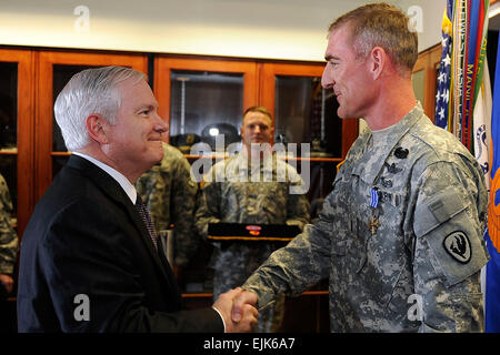 Defense Secretary Robert M. Gates congratulates Chief Warrant Officer 4 Paul F. Druse, Jr. on receiving the Distinguished Flying Cross on Cairns Army Airfield, Ala., April 14, 2009, during a two-day trip to Alabama. DOD photo by Air Force Master Sgt. Jerry Morrison Stock Photo