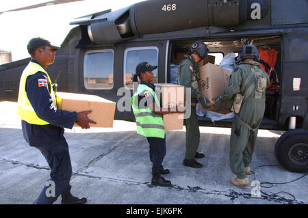 U.S. Army Soldiers and Dominicans load humanitarian relief supplies into a U.S. Army UH-60 Black Hawk helicopter in Santo Domingo, Dominican Republic, Nov. 4, 2007, in preparation for delivery. U.S. Southern Command is deployed to conduct disaster relief operations in response to Tropical Storm Noel.  Juan Torres-Diaz Stock Photo