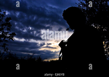 U.S. Army Staff Sgt. Charles Stokes pauses while on patrol in a local village near Combat Outpost Terezayi, April 10.  U.S. Army Spc. Eric-James Estrada Stock Photo