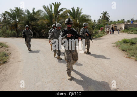 U.S. Soldiers assigned to 3rd Platoon, Bravo Company, 1st Battalion, 68th Armored Regiment, 3rd Brigade Combat Team, 4th Infantry Division patrol fields out side of Joint Security Station Basra Operation Center, Iraq, July 23. U.S. Soldiers with 3rd Platoon, Bravo Company searched the area for weapon caches and intelligence. Stock Photo