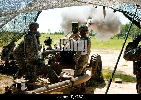 Cannon crewmember Paratroopers with Battery B, 1st Battalion, 319th Airborne Field Artillery Regiment, 3rd Brigade Combat Team, 82nd Airborne Division fire high-explosive artillery rounds from an M-119A2 Howitzer during the battery's field training exercise June 27, 2012.  &quot;This FTX is good training for us right now,&quot; said Sgt. Joseph Liddle, a Battery B section chief.  &quot;It gives the newer guys a greater concept understanding and a view of the moving pieces on the battlefield.&quot; Stock Photo