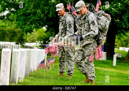 Army Pvt. Aaron Johnson places a small American flag in front of a grave during the annual &quot;Flags In&quot; event at Arlington National Cemetery in Arlington, Va., May 24, 2012. Johnson, assigned to the 3rd Infantry Regiment, the Army's &quot;Old Guard,&quot; was one of several soldiers to place place flags in front of more than 260,000 gravestones and about 7,300 niches at the cemetery's columbarium.  Sgt. Jose A. Torres Jr. Stock Photo