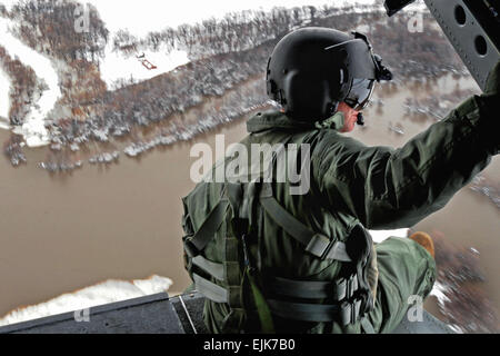 U.S. Army Staff Sgt. Jon Scarber, a flight engineer, looks out over the flooded Red River along the North Dakota-Minnesota border from a  CH-47D Chinook helicopter, April 1, 2009. The Montana Army National  Guard is assisting flood relief efforts around Grand Forks, N.D., and is conducting flights to familiarize aviators and soldiers with possible hazards in the region. The soldiers are assigned to the 1st Battalion, 189th Aviation Regiment.    Sgt. 1st  Class Roger M. Dey Stock Photo
