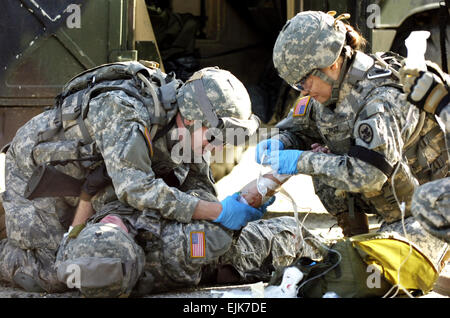 U.S. Army 1st Lts. Andrew Richardson and Kim Cruz, both of the 131st Mobile Public Affairs Detachment out of Montgomery, Ala., remove a needle and taping gauze from simulated casualty Sgt. Brandon McCarty during medical training at Fort Dix, N.J., May 3, 2007. The Soldiers are being trained by 1st Army Public Affairs in preparation for a mission in support of U.S. Army Central Command.  Staff Sgt. Russel Lee Klika, U.S. Army. Stock Photo