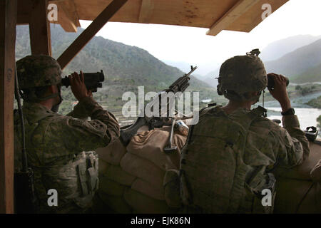Two U.S. Army Soldiers from Charlie Troop, 3rd Squadron, 61st Cavalry Regiment, keep an eye out while performing guard duty, July 7, at Combat Post Pirtle King, Afghanistan. The main focus of the outpost is to maintain control over the Tsunnel valley, an area formally used as a high traffic route for Al Queda.  Staff Sgt. Christopher W. Allison, 55th Signal Company. Stock Photo