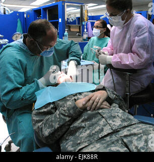 U.S. Air Force Maj. Matthew Sands and Staff Sgt. Lacy Summy perform a dental procedure on Army Spc. Sarah Hunt in the dental clinic on Schofield Barracks, Hawaii, July 19, 2007. The Airmen are deployed with the Florida Air National Guard to work and train in a joint environment alongside active duty Soldiers at Tripler Army Medical Center and the dental and optometry clinics on Schofield Barracks.  Staff Sgt. Shelley Gill Stock Photo