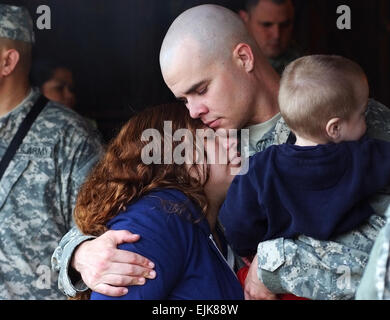 Sgt. Chad Ward, an infantry team leader with 1st Bn., 14th Inf. Regt., 2nd Stryker Brigade Combat Team, 25th Infantry Division, holds his wife, Kazia and son, Asher, at Schofield Barracks, Hawaii, before deploying in support of Operation Iraqi Freedom Jan. 30. Ward is one of nearly 100 Soldiers who are the first to deploy since the brigade’s main body left for Iraq in November. : Sgt. Matthew C. Moeller; 8th Theater Sustainment Command PAO Stock Photo