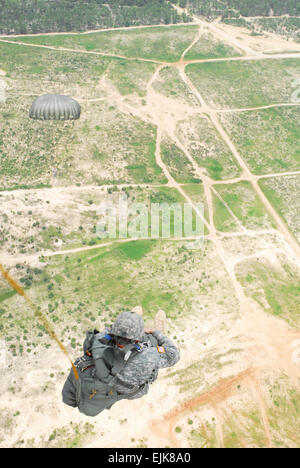 A Paratrooper from the 528th Sustainment Brigade, U.S. Army Special Operations Command braces for the release of the main parachute after exiting a UH-60 Black Hawk, Luzon Drop Zone, Camp Mackall, N.C., July 11.  U.S. Army Sgt. Christopher Freeman/50th PAD Stock Photo
