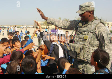A Soldier of Alpha Company, 1st Brigade Special Troops Battalion from the 10th Mountain Division‘s 1st Brigade Combat Team plays “High-Five” with a group of children at a school in the Northern Afghanistan border town of Hairatan. U.S. Army photo, courtesy 1st BSTB, 1BCT, 10th Mountain Division Stock Photo