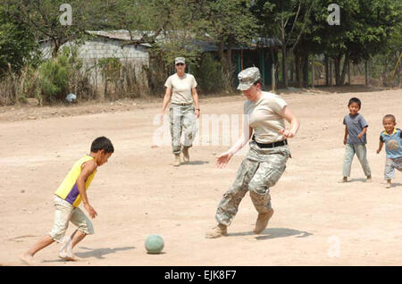 U.S. Army Spc. Teri McMurray, a medic with the 4005th Army Hospital, plays soccer with local children at a school renovation site in La Mesas, Honduras, May 2, 2008. McMurray and her unit are taking part in Beyond the Horizons, a joint training exercise wherein U.S. Army Reserve and National Guard Soldiers conduct humanitarian and civil assistance missions while developing their engineering, construction and medical skills.  Staff Sgt. Sean A. Foley Stock Photo