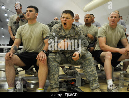 U.S. Army Staff Sgt. Robert Garcia, 28, of Denver, Colo., assigned to Bravo, 167th Combined Arms Battalion is flanked by Soldiers from his unit as he cheers for a fellow Soldier during a wrestling tournament at Forward Operating Base Marez, Mosul, Iraq, July 26. Stock Photo