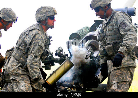 Smoke rolls out of an expended artillery round as Sgt. Flint Elsik extracts the shell from a Howitzer during a live fire training exercise, Aug. 24. Paratroopers assigned to B Battery, 2nd Battalion, 319th Airborne Field Artillery Regiment, 2nd Brigade Combat Team, 82nd Airborne Division, conducted defensive live fire exercises during the Brigade’s week-long field training exercise in preparation for a Joint Readiness Training Center rotation in October. As part of America’s Global Response Force, the Paratroopers of the 82nd Abn. Div. consistently train to be prepared to conduct any type of m Stock Photo