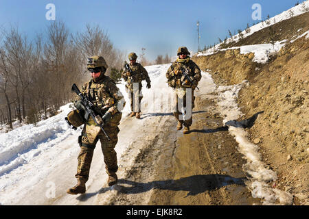 U.S. Army Sgt. Crystal Cornejo, left, and Staff Sgt. Farrell Thomey, right, and Sgt. Patrick Deleonguerrero, rear, maneuver down a snow and ice covered hill during a presence patrol in Kabul, Afghanistan, Feb. 9, 2012. Cornejo, Thomey, and Deleonguerrero are assigned to the 1186th Military Police Company.  Sgt. Catherine Threat Stock Photo