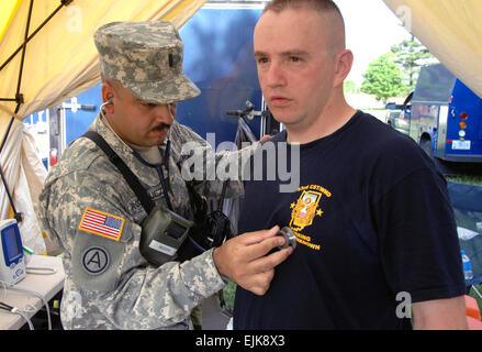 U.S. Army 1st Lt. Peter Rodriquez, a physician's assistant with the 22nd Civil Support Team, Puerto Rico National Guard, conducts a post-entry exam on Sgt. David Power, of the 53rd Civil Support Team, Indiana National Guard, during a scenario for Vigilant Guard May 10, 2007, at the Muscatatuck Urban Training Center in Indiana. The exercise is a joint military and civilian emergency management exercise hosted by the Indiana National Guard that simulates the detonation of a nuclear device in a major metropolitan area.  Sgt. Michael Krieg Stock Photo