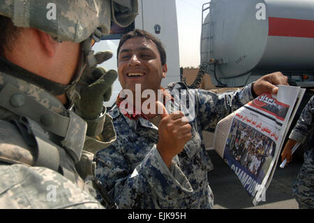 A member of the Iraqi National Police Force holds a copy of the Baghdad Now newspaper and celebrates the victory of the Iraqi national Soccer team in the Asia Cup at a checkpoint in the region of East Rashid in Baghdad, Iraq, Aug. 6, 2007. Baghdad now is a newspaper put together by the U.S. Army's Detachment 1080, 318th Psychological Operations Company that covers news from around the world as well as in Iraq.  Mass Communication Specialist 3rd Class David Quillen Stock Photo