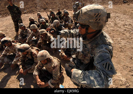 Iraqi army soldiers from 2nd Light Infantry Battalion, 3rd Brigade Combat Team, 8th Army Division listen as U.S. Army Staff Sgt. Ditson Abraham, from 0832 Military Transition Team, gives a class on dismounted tactical movement techniques during training on Battle Position Eagle in Tanmiya, Iraq, Feb. 14, 2008.  Sgt. Timothy Kingston Stock Photo
