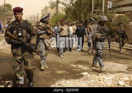 U.S. Army Soldiers assigned to 5th Battalion, 25th Field Artillery Regiment, 4th Brigade Combat Team, 10th Mountain Division, Iraqi National Police from 3rd Battalion, 1st Brigade Combat Team, 1st Division and Iraqi army soldiers conduct a search mission for illegal firearms and improvised explosive device caches in Baghdad, Iraq, March 15, 2008.  Staff Sgt. Jason T. Bailey Released Stock Photo