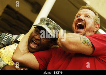 U.S. Army Sgt. Maj. Sheon Alderman, of 5th Battalion, 25th Field Artillery Regiment, 4th Brigade Combat Team, 10th Mountain Division, enjoys a visit with former professional wrestler Diamond Dallas Page during the Ambassadors of Hollywood Tour sponsored by Morale, Welfare and Recreation on Forward Operating Base Rustamiyah in Baghdad, Iraq, March 13, 2008.  Staff Sgt. Jason T. Bailey Stock Photo