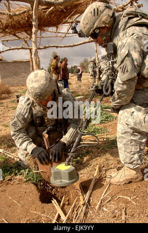 U.S. Army Staff Sgt. Matthew Jemison, digs as Sgt. Paul Griffin search for hidden weapons caches with a metal dector near a village southeast of Salman Pak, Iraq, Feb. 15, 2008. Both Soldiers are with Command Security Detachment, 1st Battalion, 15th Infantry Regiment, 3rd Heavy Brigade Combat Team, 3rd Infantry Division.  Sgt. Timothy Kingston Stock Photo