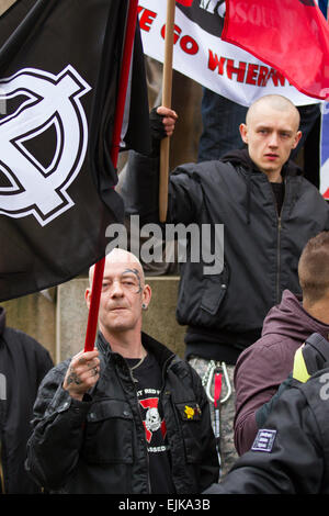 Manchester, UK 28th March, 2015. Far right demonstrators with flags & banners at the National Front and White Pride Demo in Piccadilly.  Arrests were made as Far Right 'White Pride' supremacists group gathered in Manchester to stage a demonstration when about 50 members of the group waved flags and marched through Piccadilly Gardens. Anti-fascist campaigners staged a counter-demonstration and police line separated the two sides. Greater Manchester Police said two arrests were made, one for a breach of the peace. The second was also held for a public order offence. Stock Photo