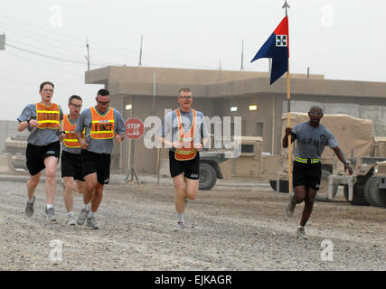 2nd place. FORWARD OPERATING BASE FALCON, Iraq  1st Sgt. Reuben Tull hoists the Headquarters and Headquarters Detachment guidon as his teammates, Maj. Dave Olson, Lt. Col. Jeffrey Mullins, Maj. Christopher Taylor, 1st Lt. Katherine Fenton, approach the finish line during a 5k Fun Run May 17 at Forward Operating Base Falcon, Baghdad. Three teams from the 1st Brigade Combat Team, 4th Infantry Division, Multi-National Division  Baghdad, finished behind the 1st Place team from Company F Forward Support Company, attached to the 2nd Brigade Combat Team, 3rd Infantry Division in the run. The Falcon 5 Stock Photo