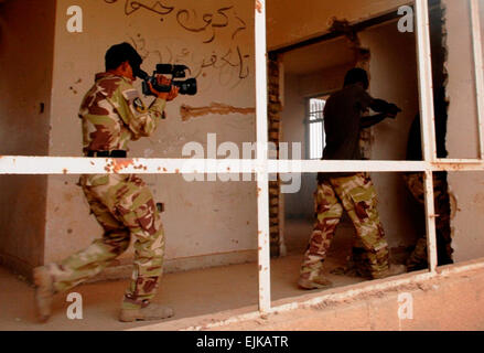 BAGHDAD, Iraq – Iraqi Special Operations Forces practice clearing a building looking for a suspect during their combat camera course in March. Seven members of the ISOF have graduated the first Iraqi instructed combat camera course May 6. The 10-day course teaches the soldiers the basics of the camera and how to successfully document activities and missions within their brigades. The first week of the instruction led the soldiers through the inner working of the still camera, outside and in a studio setting. The second week showed taught them how to shoot during daylight and night hours with a Stock Photo