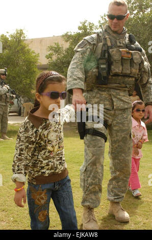 Iraqi Girl Travels to U.S. in Effort to Repair Vision  Sgt. David Turner May 27, 2008  Noor, a young girl receiving eye surgery in the U.S., leads 1st Lt. Michael Kendrick on a walk through her yard in al-Buaytha May 25. Noor is wearing the sunglasses Kendrick's wife sent her as a gift.  see: /-news/2008/05/27/9433-iraqi-girl-travels-to-...  /-news/2008/05/27/9433-iraqi-girl-travels-to-us-in-effort-to-repair-vision/ Stock Photo