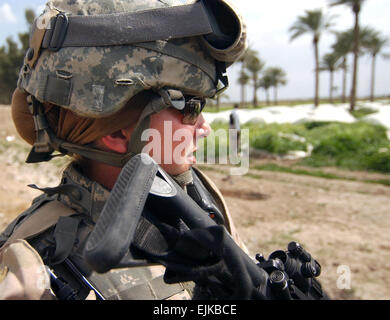 U.S. Army Sgt. Ashley Hort keeps her weapon at the ready as she provides security for her fellow soldiers during a raid in Al Haswah, Iraq, on March 21, 2007.  Hort is a team sergeant with the 127th Military Police Company deployed from Hanau, Germany.  Spc. Olanrewaju Akinwunmi, U.S. Army. Stock Photo