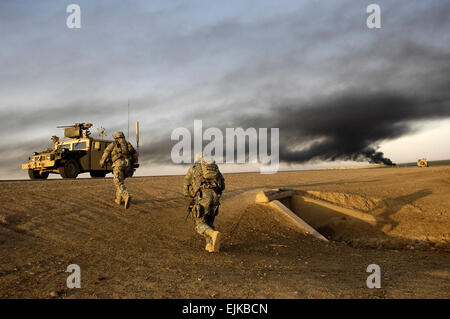 U.S. Army Sgt. Sean Bundy and Sgt. Dennis First walk to the rally point to link up with the Iraqi army soldiers from 1st Battalion, 2nd Brigade, 4th Iraqi Army Division for an Iraqi army-led operation in Al Muradia village, Iraq, March 12, 2007. Bundy and First are assigned to 4th Platoon, Delta Company, 2nd Battalion, 27th Infantry Regiment, 3rd Brigade Combat Team, 25th Infantry Division, Schofield Barracks, Hawaii.  Master Sgt. Andy Dunaway Stock Photo