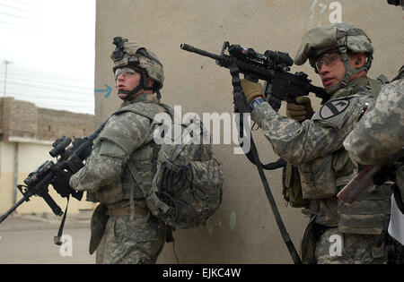 U.S. Army Pvt. Joseph Burton and Staff Sgt. John Martinez clear a street corner during a raid in the Tamooz neighborhood of Mosul, Iraq, April 27, 2007. The Soldiers are with 3rd platoon, Delta Company, 2nd Battalion, 7th Cavalry Regiment, 4th Brigade Combat Team, 1st Cavalry Division.  Staff Sgt. Vanessa Valentine Stock Photo