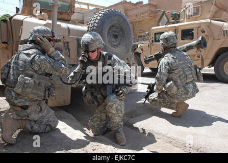 070616-A-5406P-003.JPG - from left Sgt. Jake Richardson, of St. Johns, Ariz., 1st Lt. Travis Atwood, of Abilene Texas, and Staff Sgt. Michael Mullahy, of Batavia, Ill. take cover while Mullahy prepares to fire an AT4 rocket launcher at an insurgent position during a firefight in Baghdad's Adhamiyah neighborhood June 16 that ended with one insurgent dead and three captured. All three Soldiers are with Charlie Company, 1st Battalion, 26th Infantry Regiment, based in Schweinfurt, Germany.  Sgt. Mike Pryor, 2nd BCT, 82nd Airborne Division Public Affairs Stock Photo