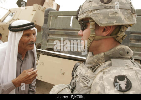 U.S. Army Sgt. Jeff Woodford speaks with an Iraqi man waiting to receive medical care during a cooperative medical engagement in Al Madinah As Siyahiyah, Iraq, on May 16, 2007.  Iraqi army soldiers from the 1st Iraqi Army Division, with assistance from U.S. Marines from Alpha Company, 2nd Combined Arms Battalion, 136th Infantry Regiment, 2nd Marine Logistics Group Forward, are providing medical care to Iraqi civilians.    Sgt. Bobby J. Segovia, U.S. Marine Corps. Stock Photo