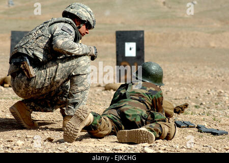 U.S. Army Staff Sgt. Derek Renaud, 34, of Angola, New York, looks on as an Afghan national army soldier tries zeroing his weapon at Kabul Military Training Center, March 17. Renaud, officer in charge of the range during qualification and zeroing of M16s, mentors ANA recruits as they learn to use their new M16s. He's a member of the Camp Alamo Mentor Group's Basic Warrior Training branch.  Guy Volb Stock Photo